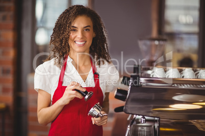 A smiling barista pressing coffee