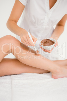 Therapist waxing womans leg at spa center