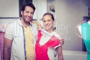 Smiling couple showing dress to camera