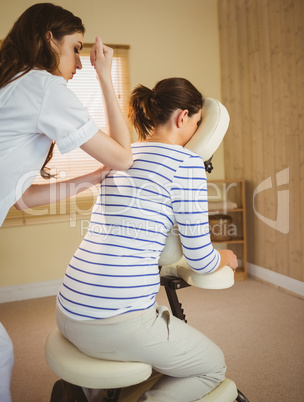 Young woman getting massage in chair