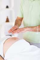 Close up view of pregnant woman getting reiki treatment