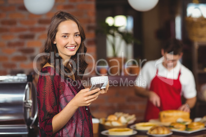 Pretty woman holding a cup of coffee and texting