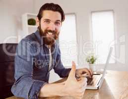 Hipster businessman showing thumbs up to camera