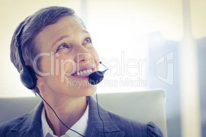 Smiling businesswoman phoning with headphone