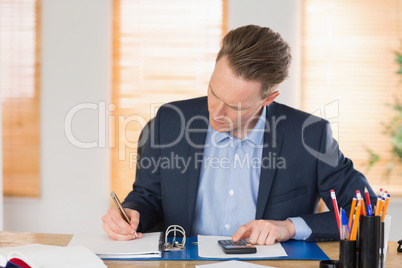 Concentrated businessman writing down