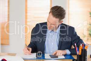 Concentrated businessman writing down