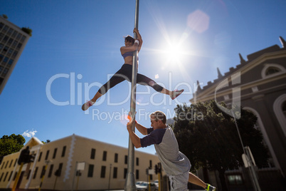 Extreme athletes hanging on street sign