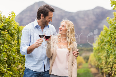 Young happy couple holding a glass of wine and looking at each o