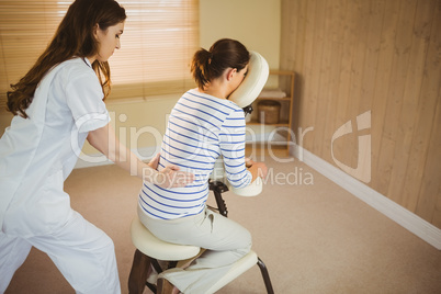 Young woman getting massage in chair