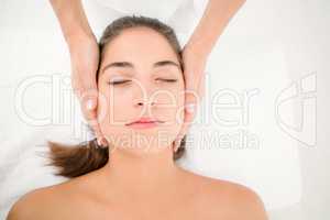 Attractive woman receiving facial massage at spa center