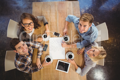 Smiling friends sitting and drinking coffee