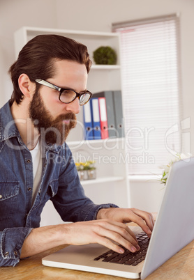 Hipster businessman working on laptop