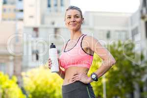 A beautiful woman holding a sports bottle of water