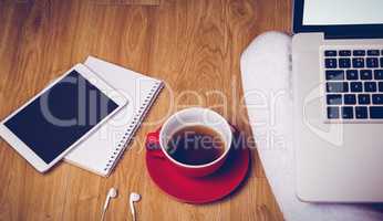 Overhead shot of laptop, tablet, coffee and headphones