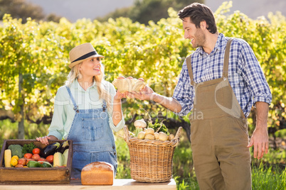 Happy farmer couple handing eggs