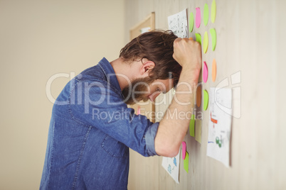 Bearded hipster frustrated at brainstorm wall