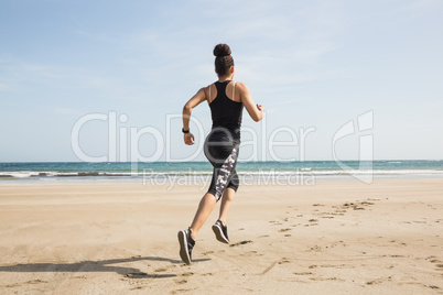 Fit woman jogging on the sand Fit woman jogging on the sand