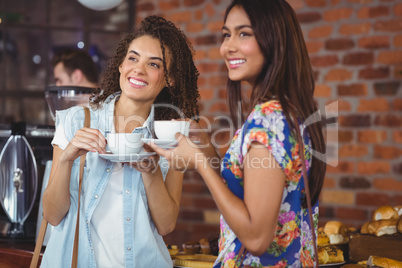 Smiling pretty customers with coffee cups