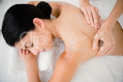 Woman enjoying a salt scrub massage