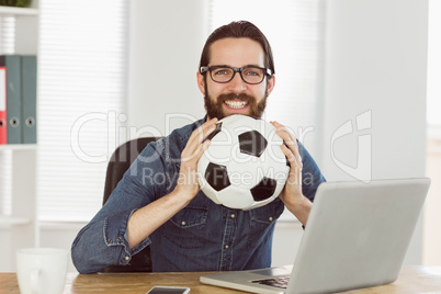 Hipster businessman holding a football