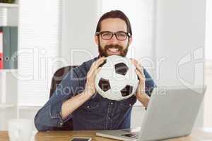 Hipster businessman holding a football