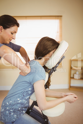 Young woman getting massage in chair