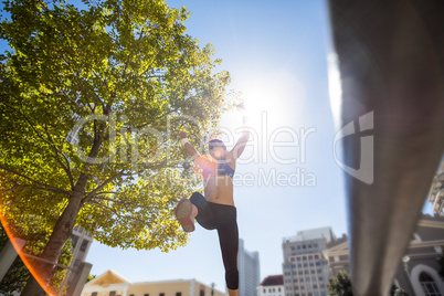 Athletic woman leaping and holding arms up in the air