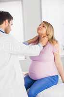 Doctor examining neck of pregnant patient