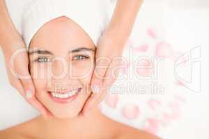 Attractive woman receiving facial massage at spa center