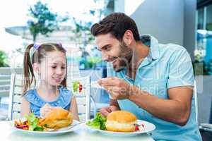 Daughter and father eating at the restaurant