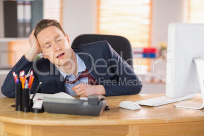 Exhausted businessman sleeping at his desk