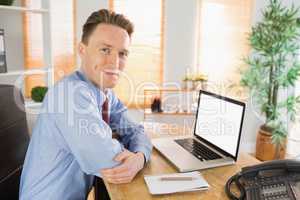 Happy businessman working with laptop