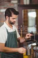 Barista steaming milk at the coffee machine