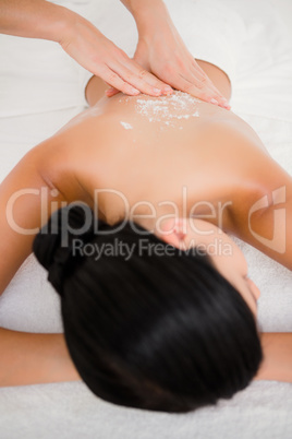 Woman enjoying a salt scrub massage