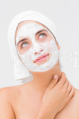 Thoughtful woman having white cream on her face
