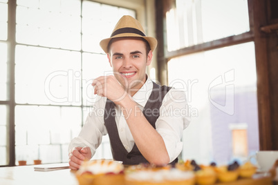 Smiling hipster sitting next to treats