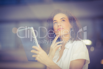 Thoughtful woman using a digital tablet