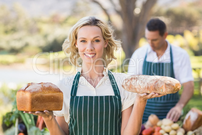 Smiling farmer woman holding breads