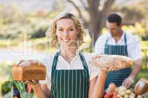 Smiling farmer woman holding breads