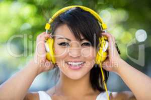 Portrait of athletic woman wearing yellow headphones and enjoyin