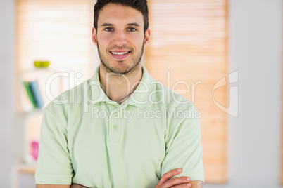 Portrait of smiling handsome masseur with arms crossed