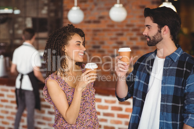 Smiling hipster couple with take-away cups