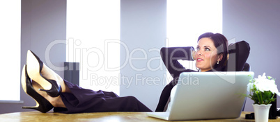 Businesswoman relaxing at her desk Businesswoman relaxing at her desk