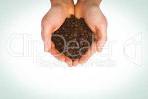 Close up view of hands showing coffee beans