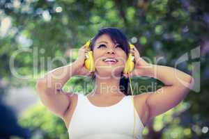 Athletic woman wearing yellow headphones and enjoying music
