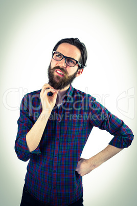 Handsome hipster thinking and scratching beard