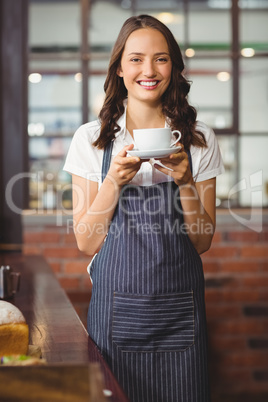 Pretty waitress offering a cup of coffee