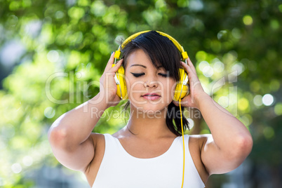 Athletic woman wearing yellow headphones and enjoying music with