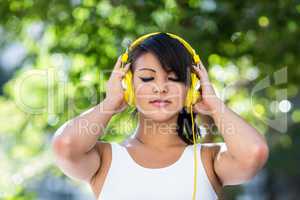 Athletic woman wearing yellow headphones and enjoying music with