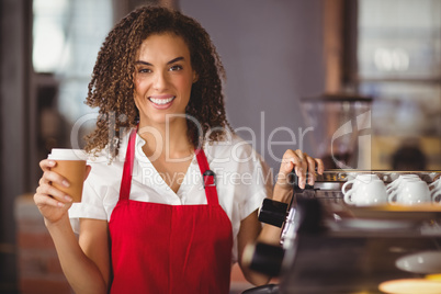 Pretty waitress holding a take-away mug